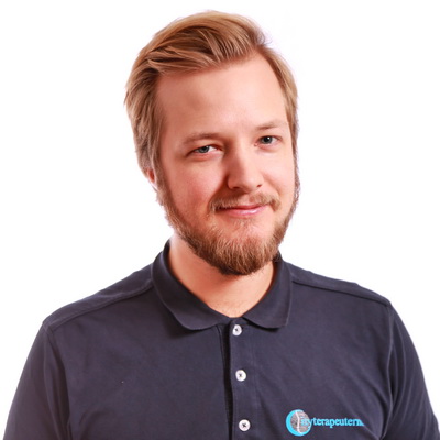 Porträttfotografi av Nils Johansson, Kiropraktor, iklädd mörkblå pikétröja med Cityterapeuternas logotyp.